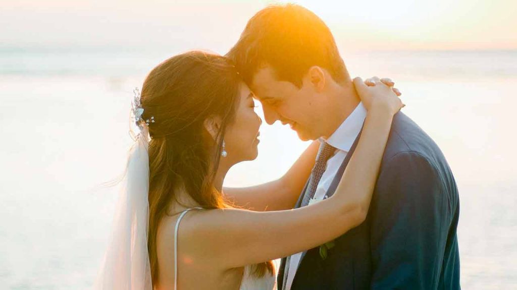A Western man and a Filipina woman enjoying a sunset on a beach in the Philippines