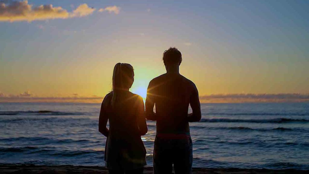 A silhouette of a couple enjoying a romantic dinner date at a restaurant with a city view.