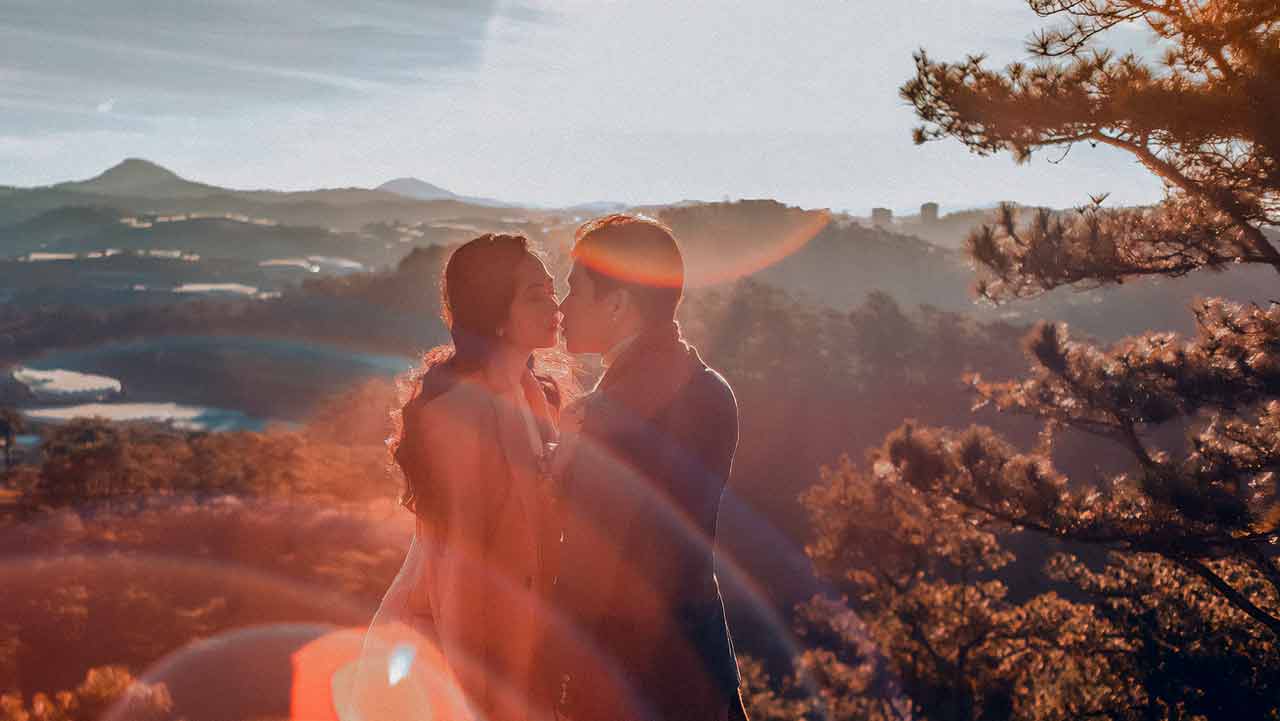 A smiling Black man and his Asian wife embracing warmly outdoors, representing a successful interracial relationship.